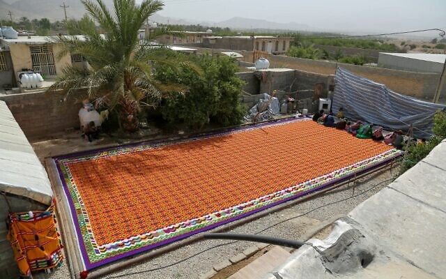 Des Iraniennes travaillent au tissage du plus grand kilim du monde à Qirokarzin, dans la province de Fars (sud), le 25 juin 2022. (Crédit : FARZANEH CHAKHMAGH ZAS / Iran's Young Journalists Club / AFP)