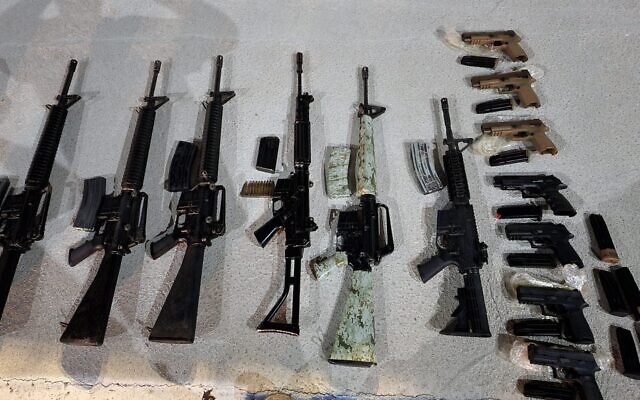 Armes saisies par les forces de sécurité près de Neot Hakikar, dans le sud d'Israël, après une opération présumée de trafic d'armes à feu à la frontière avec la Jordanie, le 20 juin 2022. (Crédit : Police israélienne)