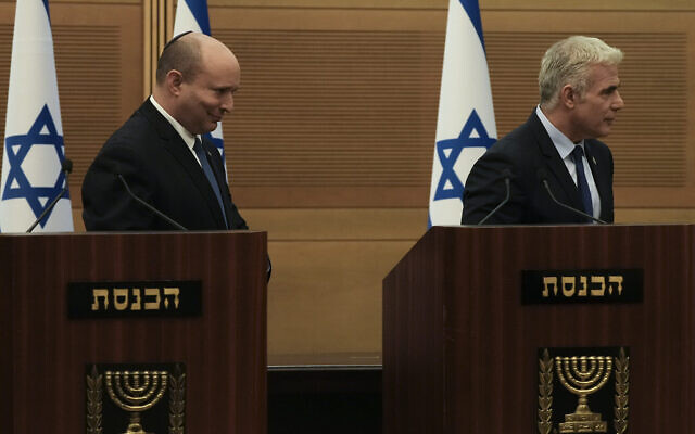Le Premier ministre israélien Naftali Bennett, à gauche, et le ministre des Affaires étrangères Yair Lapid, quittent leur podium après une déclaration commune à la Knesset, annonçant l'effondrement de leur coalition, lundi 20 juin 2022. (Crédit : Maya Alleruzzo/AP) Le Premier ministre israélien Naftali Bennett, à gauche, et le ministre des Affaires étrangères Yair Lapid, quittent leur podium après une déclaration commune à la Knesset, annonçant l'effondrement de leur coalition, lundi 20 juin 2022. (Crédit : Maya Alleruzzo/AP)