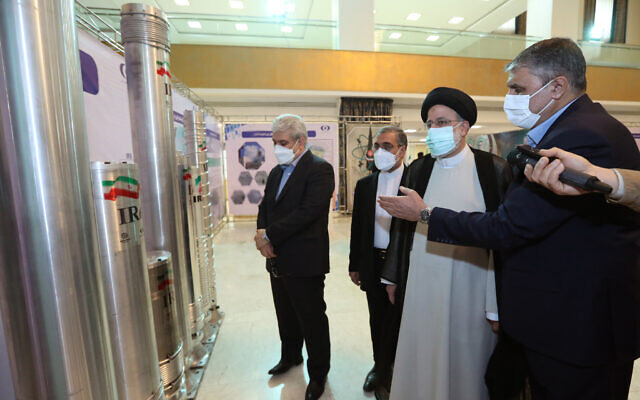 Le président iranien Ebrahim Raissi (2e à droite) écoutant une explication tout en regardant une centrifugeuse lors d'une exposition sur les réalisations nucléaires de l'Iran, à Téhéran, en Iran, le 9 avril 2022. (Crédit : Bureau du président iranien) Le président iranien Ebrahim Raissi (2e à droite) écoutant une explication tout en regardant une centrifugeuse lors d'une exposition sur les réalisations nucléaires de l'Iran, à Téhéran, en Iran, le 9 avril 2022. (Crédit : Bureau du président iranien)