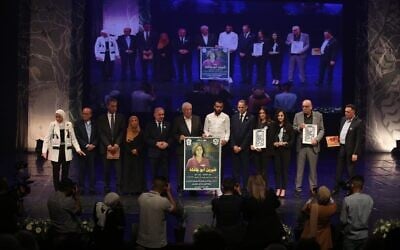 De hauts responsables palestiniens, dont le Premier ministre Mohammad Shtayyeh, aux côtés de la famille de la journaliste d'Al-Jazeera Shireen Abu Akleh lors d'une cérémonie de commémoration à Ramallah, le 19 juin 2022. (Crédit : WAFA/Mahmoud Abu Zeid)
