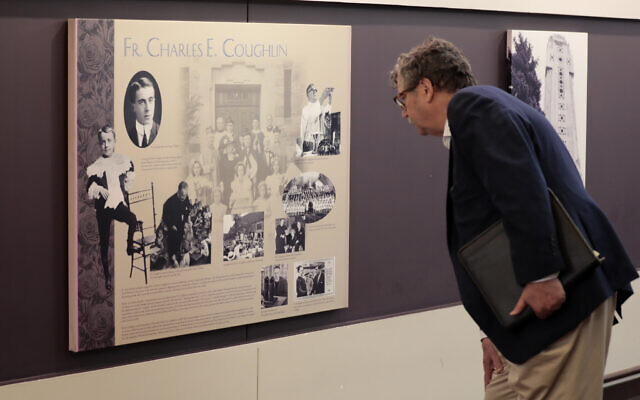 Levi Smith regarde une plaque du Père Charles Coughlin dans le hall du Sanctuaire de la Petite Fleur à Royal Oak, Michigan, le 31 mai 2022, avant une "discussion sur les relations entre Juifs et catholiques". L'événement était co-parrainé par le JCRC/AJC de Détroit et l'archidiocèse de Détroit. Le sanctuaire a été fondé par le père Coughlin, qui avait une émission de radio antisémite dans les années 1930. (Crédit : Jeff Kowalsky pour JTA)