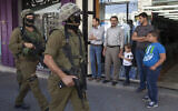 Illustration : Des soldats israéliens dans un marché de Hébron le 19 juin 2014. (Crédit : AP/Majdi Mohammed)
