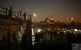 Illustration : Avec en toile de fond la mosquée Suleymaniye, des passants flânent le long des rives du Bosphore à Istanbul, en Turquie, le 23 octobre 2020. (Crédit : AP Photo/Emrah Gurel)
