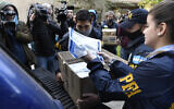 Des policiers confisquent une boîte de documents lors d'une descente judiciaire à l'hôtel Plaza Central où se trouve l'équipage d'un Boeing 747 cargo appartenant au Venezuela, à Buenos Aires, en Argentine, mardi 14 juin 2022. (Crédit : AP Photo/Gustavo Garello)