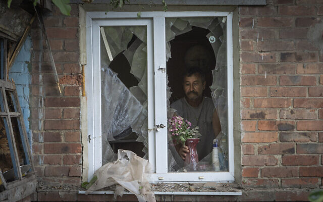 Un habitant place un vase avec des fleurs sur une fenêtre brisée de sa maison endommagée par les bombardements russes à Bakhmut, dans la région de Donetsk, en Ukraine, dimanche 26 juin 2022 (AP Photo/Efrem Lukatsky). Un habitant place un vase avec des fleurs sur une fenêtre brisée de sa maison endommagée par les bombardements russes à Bakhmut, dans la région de Donetsk, en Ukraine, dimanche 26 juin 2022 (AP Photo/Efrem Lukatsky).