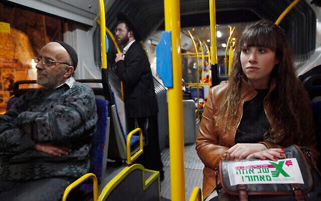 Illustration : Des Israéliens laïcs montant dans un bus où est instaurée la séparation entre hommes (à l’avant) et femmes (à l’arrière). Des femmes laïques se sont assises à l'avant, au milieu d'hommes juifs ultra-orthodoxes, dans le cadre d'une protestation contre l'exclusion des femmes dans la sphère publique, le 1er janvier 2012. (Crédit: Miriam Alster/Flash90)