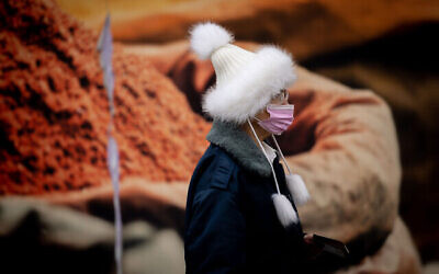 Une femme portant un masque, dans le centre-ville de Jérusalem, le 16 mars 2022. (Crédit : Yonatan Sindel/Flash90)