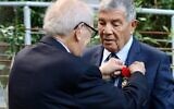 L’historien français Serge Klarsfeld décore Avner Shalev, qui a dirigé le musée-mémorial de Yad Vashem, à Jérusalem, pendant 27 ans, des insignes d'Officier de la Légion d’honneur, en juin 2022, à l’Ambassade de France en Israël, à Tel Aviv. (Crédit : Twitter / La France en Israël)