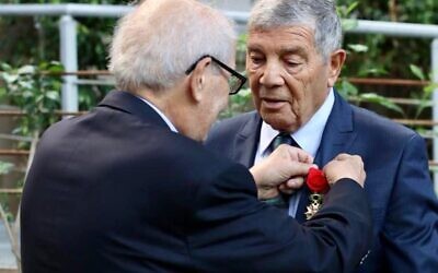 L’historien français Serge Klarsfeld décore Avner Shalev, qui a dirigé le musée-mémorial de Yad Vashem, à Jérusalem, pendant 27 ans, des insignes d'Officier de la Légion d’honneur, en juin 2022, à l’Ambassade de France en Israël, à Tel Aviv. (Crédit : Twitter / La France en Israël)