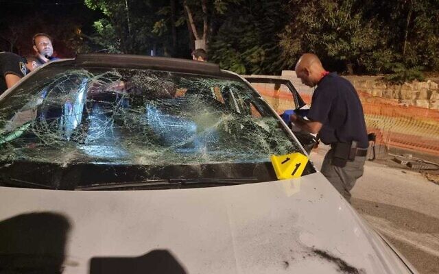 Des policiers inspectant une voiture endommagée par des pierres à Jérusalem-Est, le 8 juin 2022. (Crédit: Police israélienne) Des policiers inspectant une voiture endommagée par des pierres à Jérusalem-Est, le 8 juin 2022. (Crédit: Police israélienne)