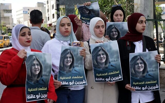 Des Palestiniennes tiennent des affiches à l'effigie de Shireen Abu Akleh, journaliste d'Al Jazeera, qui a été tuée lors d'affrontements entre les troupes israéliennes et des tireurs palestiniens alors qu'elle couvrait un raid à Jénine, le 11 mai 2022. (Crédit : HAZEM BADER / AFP) Des Palestiniennes tiennent des affiches à l'effigie de Shireen Abu Akleh, journaliste d'Al Jazeera, qui a été tuée lors d'affrontements entre les troupes israéliennes et des tireurs palestiniens alors qu'elle couvrait un raid à Jénine, le 11 mai 2022. (Crédit : HAZEM BADER / AFP)