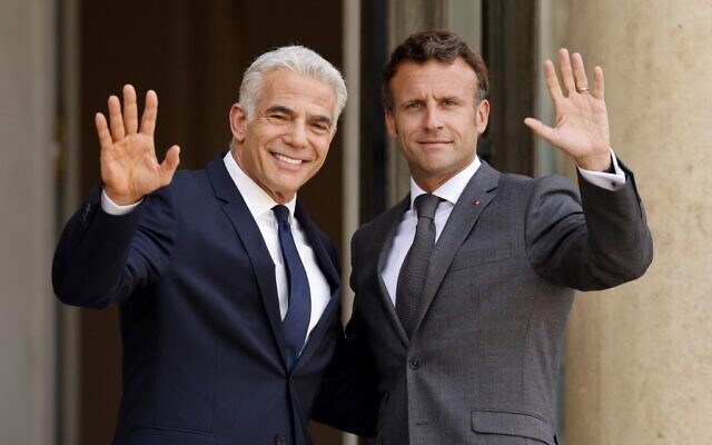 Le président français Emmanuel Macron (R) accueille le Premier ministre israélien Yaïr Lapid avant leur rencontre au palais de l'Élysée à Paris, le 5 juillet 2022. (Crédit : Ludovic MARIN / AFP) Le président français Emmanuel Macron (R) accueille le Premier ministre israélien Yaïr Lapid avant leur rencontre au palais de l'Élysée à Paris, le 5 juillet 2022. (Crédit : Ludovic MARIN / AFP)
