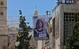 Une bannière montrant la journaliste d'Al Jazeera tuée par balle Shireen Abu Akleh accrochée à un bâtiment surplombant l'église de la Nativité à Bethléem, en Cisjordanie, le 14 juillet 2022. (Crédit :  Ahmad Gharabli/AFP)