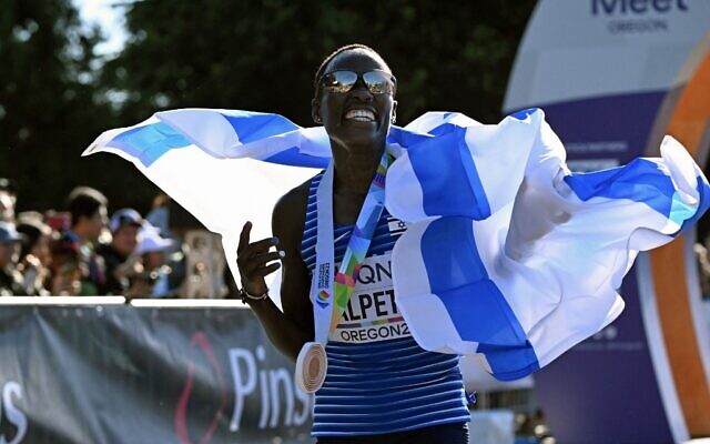 La médaillée de bronze d'Israël, Lonah Chemtai Salpeter, célèbre après avoir franchi la ligne d'arrivée de la finale du marathon féminin, lors des Championnats du monde d'athlétisme à Eugene, en Oregon, le 18 juillet 2022. (Crédit : Jim WATSON/AFP)