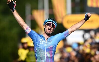 Hugo Houle, coureur canadien de l'équipe Israel-Premier Tech, célèbre sa victoire alors qu'il se dirige vers la ligne d'arrivée de la 16e étape de la 109e édition du Tour de France, 178,5 km entre Carcassonne et Foix dans le sud de la France, le 19 juillet 2022. (Crédit : Marco BERTORELLO / AFP)