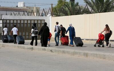 Des passagers arrivant du côté jordanien du pont Allenby, qui relie la Cisjordanie et la Jordanie, le 19 juillet 2022. (Crédit : Khalil Mazraawi/AFP)