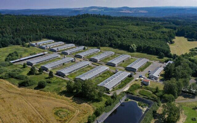 Une photo aérienne prise le 22 juillet 2022 montre la ferme porcine industrielle située sur le site d'un ancien camp de concentration rom à Lety, en République tchèque. Quelque 1 300 Roms ont été emprisonnés dans le camp de Lety pendant la Seconde Guerre mondiale, travaillant dans une carrière, sur la construction de routes, dans les champs et les forêts.
Au total, 327 personnes sont mortes ici, dont 241 enfants de moins de 14 ans. Le régime communiste de l'ancienne Tchécoslovaquie a construit la ferme porcine sur le site dans les années 1970. (Crédit : Tomas Novak / AFP)