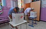 Des Tunisiens votent lors d'un référendum sur un projet de constitution présenté par le président du pays, dans un bureau de vote du quartier de l'Ariana, près de la capitale, le 25 juillet 2022. (Crédit : FETHI BELAID / AFP)