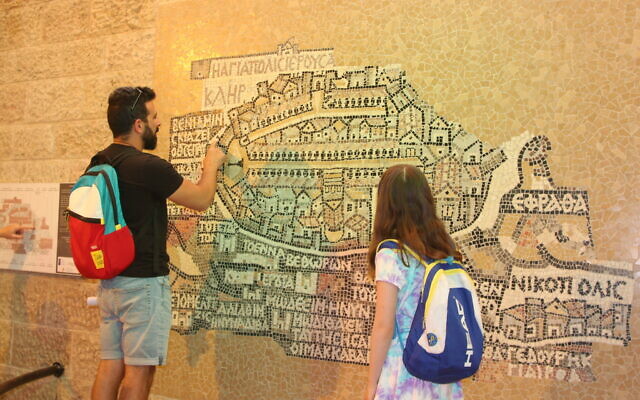 Le guide touristique Idan Pinhas montre la carte de Madaba dans le cardo de Jérusalem, juin 2022. (Crédit : Shmuel Bar-Am)