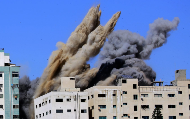 De la fumée s'élève de la tour Al-Jalaa dans la ville de Gaza, qui abritait des appartements et plusieurs agences de presse, dont l'Associated Press et Al Jazeera, après une frappe aérienne israélienne, le 15 mai 2021. (Crédit : Atia Mohammed/Flash90) De la fumée s'élève de la tour Al-Jalaa dans la ville de Gaza, qui abritait des appartements et plusieurs agences de presse, dont l'Associated Press et Al Jazeera, après une frappe aérienne israélienne, le 15 mai 2021. (Crédit : Atia Mohammed/Flash90)