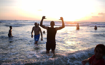 Des musulmans, le troisième jour de l'Aïd al-Adha, au bord de mer à Tel Aviv le 11 juillet 2022. (Crédit : Tomer Neuberg/Flash90)