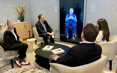 Le deuxième gentilhomme Doug Emhoff, deuxième à partir de la gauche, parle au double IA du survivant de la Shoah Pinchas Gutter par vidéo interactive. (Crédit : Jacob Gurvis/JTA)