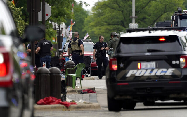 Les forces de l'ordre américaines effectuent des recherches dans le centre-ville de Highland Park, dans la banlieue de Chicago, après une fusillade lors du défilé du 4 juillet à Highland Park, le 4 juillet 2022. (AP Photo/Nam Y. Huh) Les forces de l'ordre américaines effectuent des recherches dans le centre-ville de Highland Park, dans la banlieue de Chicago, après une fusillade lors du défilé du 4 juillet à Highland Park, le 4 juillet 2022. (AP Photo/Nam Y. Huh)