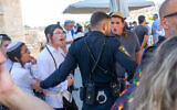 Un policier se tenant entre un groupe de jeunes ultra-orthodoxes et une cérémonie de bar mitzvah à la section égalitaire du mur de l’Ouest, le 30 juin 2022. (Crédit : Laura Ben-David)
