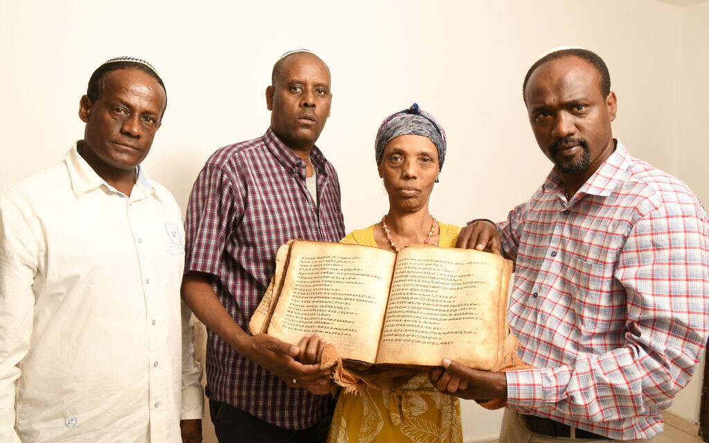 Ayanawo Ferada Senebato, à droite, et sa famille à Ashkelon, en Israël, tenant un ancien livre d'Orit qu'ils ont récupéré près de Gondar, en Éthiopie, en février 2022. (Crédit : Yossi Zeliger via JTA) Ayanawo Ferada Senebato, à droite, et sa famille à Ashkelon, en Israël, tenant un ancien livre d'Orit qu'ils ont récupéré près de Gondar, en Éthiopie, en février 2022. (Crédit : Yossi Zeliger via JTA)