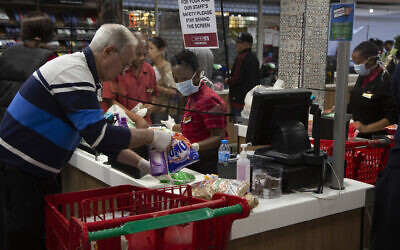 Des personnes faisant leurs achats dans un supermarché SPAR à Johannesburg, en Afrique du Sud, le 24 mars 2020 (Crédit : AP Photo/Denis Farrell)
