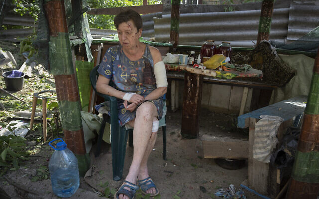 Une femme blessée quand sa maison a été détruite par les obus russe est assise, choquée, dans son jardin à Bakhmut, dans la région de Donetsk, en Ukraine, le 26 juin 2022. (Crédit : AP Photo/Efrem Lukatsky) Une femme blessée quand sa maison a été détruite par les obus russe est assise, choquée, dans son jardin à Bakhmut, dans la région de Donetsk, en Ukraine, le 26 juin 2022. (Crédit : AP Photo/Efrem Lukatsky)