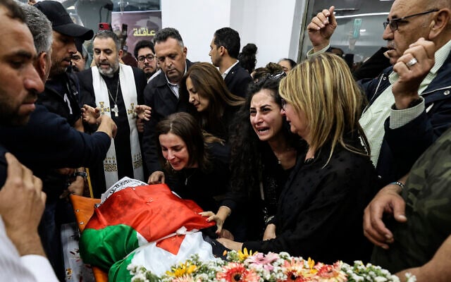Des collègues et des amis réunis autour du cercueil drapé du drapeau palestinien de la journaliste d'Al-Jazeera Shireen Abu Akleh à Ramallah, en Cisjordanie, le 11 mai 2022. (Crédit : Abbas Momani/Pool via AP, File) Des collègues et des amis réunis autour du cercueil drapé du drapeau palestinien de la journaliste d'Al-Jazeera Shireen Abu Akleh à Ramallah, en Cisjordanie, le 11 mai 2022. (Crédit : Abbas Momani/Pool via AP, File)