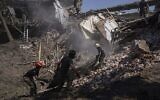 Des secouristes fouillent les décombres d’une maison détruite après une attaque russe dans un quartier résidentiel du centre-ville de Kharkiv, en Ukraine, le 9 juillet 2022. (Crédit : AP Photo/Evgeniy Maloletka)