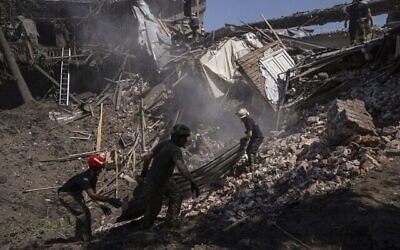 Des secouristes fouillent les décombres d’une maison détruite après une attaque russe dans un quartier résidentiel du centre-ville de Kharkiv, en Ukraine, le 9 juillet 2022. (Crédit : AP Photo/Evgeniy Maloletka)