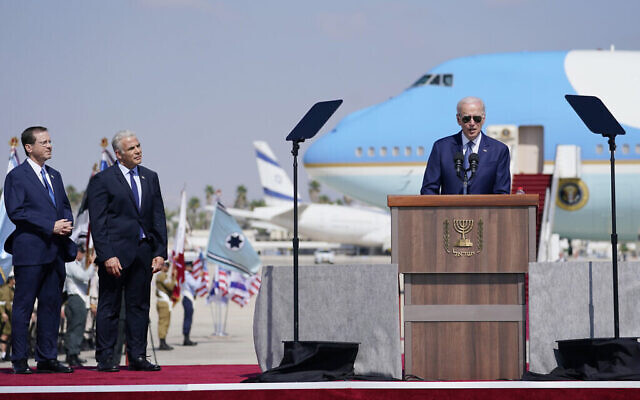 Le président Joe Biden s'exprime à son arrivée à l’aéroport Ben Gurion, le mercredi 13 juillet 2022, en présence du Premier ministre israélien Yair Lapid, deuxième à gauche, et du président Isaac Herzog, à gauche. (Crédit : AP Photo/Evan Vucci)
