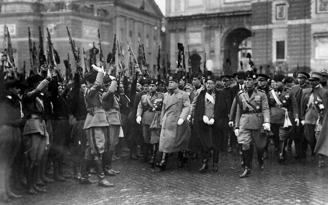 Le dictateur italien Benito Mussolini, troisième à droite, est accueilli par des troupes fascistes sur la Piazza Popolo, à Rome, le 28 mars 1928, lors de la célébration de la fondation de l’armée fasciste neuf ans plus tôt. (Crédit : AP Photo)