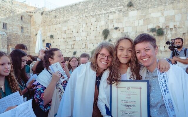 Lucia da Silva, 12 ans, de Seattle, Washington, entourée de ses mères Cara Stoddard, à droite, et Ada Danelo devant le Mur occidental, le 29 juillet 2022. (Crédit : Tal Kfir Shor via JTA) Lucia da Silva, 12 ans, de Seattle, Washington, entourée de ses mères Cara Stoddard, à droite, et Ada Danelo devant le Mur occidental, le 29 juillet 2022. (Crédit : Tal Kfir Shor via JTA)