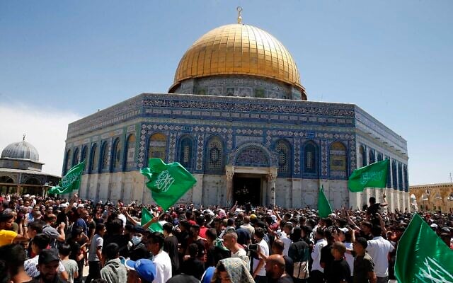 Des Palestiniens brandissent des drapeaux du Hamas après la dernière prière du vendredi du Ramadan pour manifester contre l'expulsion de familles palestiniennes de maisons revendiquées par des partisans du mouvement pro-implantation dans le quartier de Sheikh Jarrah, à Jérusalem-Est, le 7 mai 2021. (Crédit : Jamal Awad/Flash90) Des Palestiniens brandissent des drapeaux du Hamas après la dernière prière du vendredi du Ramadan pour manifester contre l'expulsion de familles palestiniennes de maisons revendiquées par des partisans du mouvement pro-implantation dans le quartier de Sheikh Jarrah, à Jérusalem-Est, le 7 mai 2021. (Crédit : Jamal Awad/Flash90)