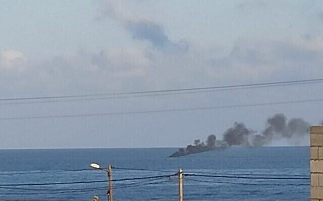 De la fumée s’élève d’un navire soupçonné de contrebande, au large de la bande de Gaza, après une ouverture de feu par la Marine israélienne. (Crédit : Réseaux sociaux)