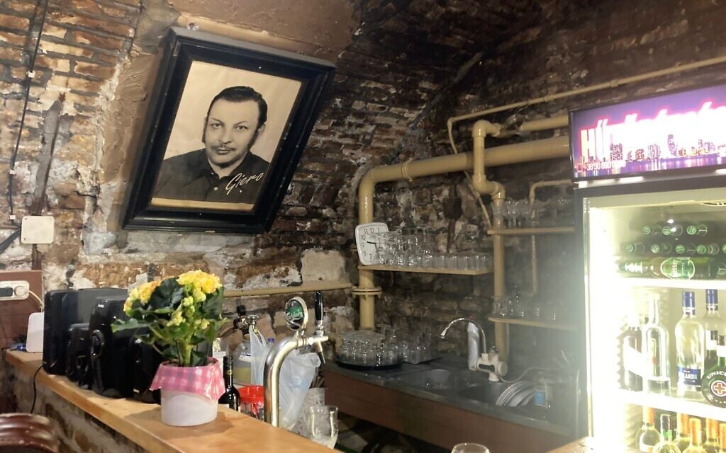 Une photo du père de Gyulane "Tante Gizi" Farkas, Giero, est accrochée au-dessus du bar du Giero Pub, à Budapest, le 12 mai 2022. (Crédit : Yaakov Schwartz/Times of Israel) 