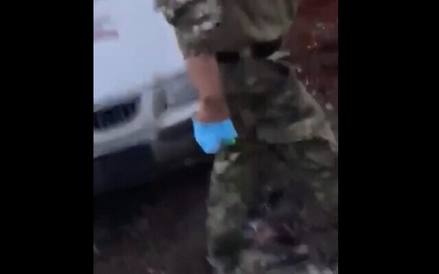 Un soldat portant des gants chirurgicaux et un cutter avant de procéder à la castration présumée d' un prisonnier sur des images qui ont circulé sur internet, le 28 juillet 2022. (Capture d'écran) Un soldat portant des gants chirurgicaux et un cutter avant de procéder à la castration présumée d' un prisonnier sur des images qui ont circulé sur internet, le 28 juillet 2022. (Capture d'écran)