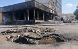 Un cratère causé par un missile russe a endommagé la rue à côté à proximité d'un centre commercial à Vinnytsia où un tir a fait 25 morts, le 20 juillet 2022. (Crédit : Lazar Berman/The Times of Israel) 