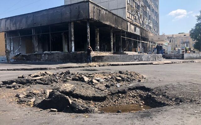 Un cratère causé par un missile russe a endommagé la rue à côté à proximité d'un centre commercial à Vinnytsia où un tir a fait 25 morts, le 20 juillet 2022. (Crédit : Lazar Berman/The Times of Israel) 