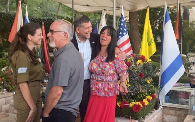 Stuart Steinberg (deuxième à gauche), Sam Grundwerg et Evie Steinberg devant la tombe du sergent Max Steinberg au cimetière militaire du mont Herzl, le 20 juillet 2022. (Crédit : Jacob Rivkin/The Times of Israel)