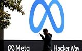 Sur cette photo prise le 28 octobre 2021, un homme passe devant le nouveau logo et le nom « Meta » affichés en devanture du siège social de Facebook à Menlo Park, en Californie. (Crédit : Justin Sullivan/ Getty Images North America/AFP)