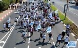Des manifestants marchant aux côtés des membres de la famille Goldin, dont le fils Hadar a été tué pendant la guerre de 2014 dans la bande de Gaza, pour exiger le retour de sa dépouille et le retour en Israël d'autres Israéliens détenus à Gaza, à Kfar Saba, le 3 août 2022. (Crédit : Jack Guez/AFP)