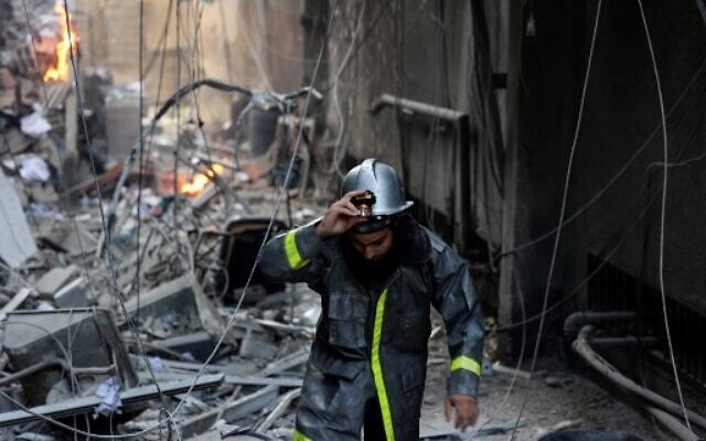 Un pompiers palestinien après une frappe aérienne israélienne sur la ville de Gaza, le 5 août 2022. (Crédit : Mohammed ABED / AFP) Un pompiers palestinien après une frappe aérienne israélienne sur la ville de Gaza, le 5 août 2022. (Crédit : Mohammed ABED / AFP)