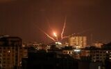 Des roquettes palestiniennes sont tirées depuis la ville de Gaza en représailles à de précédentes frappes aériennes israéliennes, le 5 août 2022. (Crédit : Mahmud Hams / AFP)