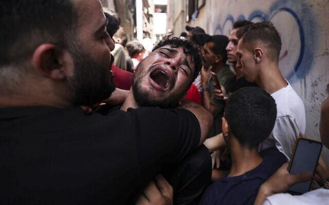 Un ami d'un jeune Palestinien tué pendant la nuit dans des circonstances contestées dans le camp de réfugiés de Jabaliya, dans le nord de la bande de Gaza, réagit pendant ses funérailles, le 7 août 2022. (Crédit : Mahmud Hams/AFP) Un ami d'un jeune Palestinien tué pendant la nuit dans des circonstances contestées dans le camp de réfugiés de Jabaliya, dans le nord de la bande de Gaza, réagit pendant ses funérailles, le 7 août 2022. (Crédit : Mahmud Hams/AFP)